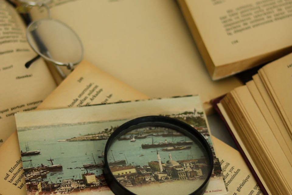 A magnifying glass and open books for reference