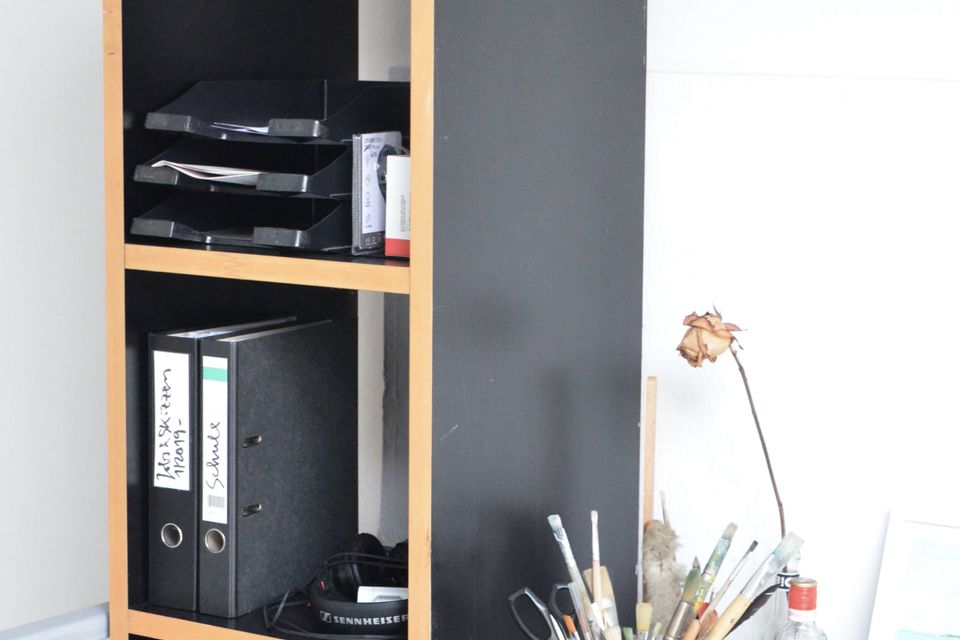 Document folders organised on a shelf beside a desk