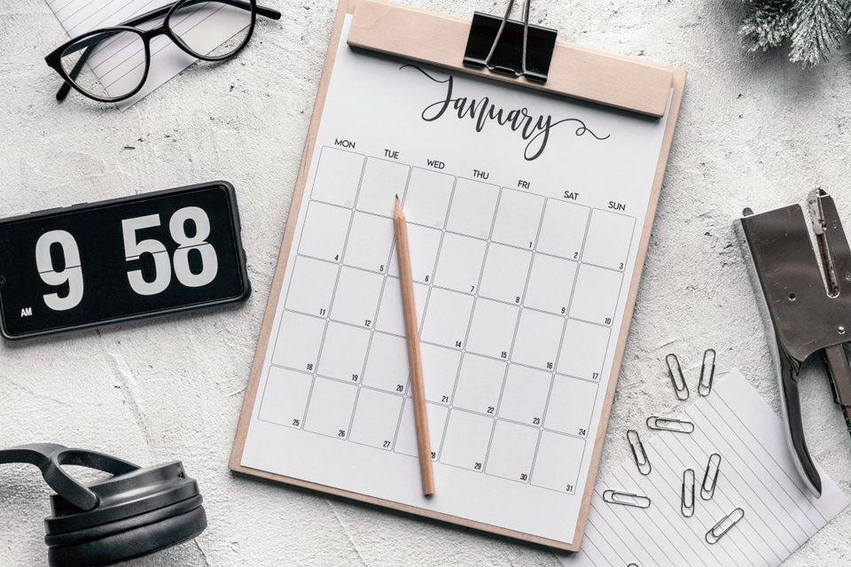 A desk calendar with glasses, a clock and stationery
