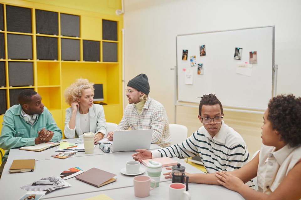 A team discussing papers around a workshop table